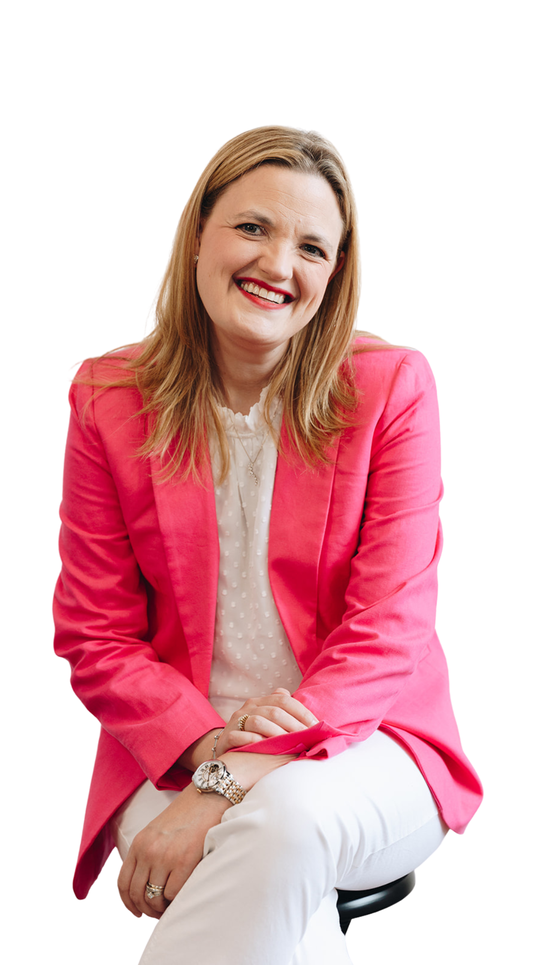 Brooke Greening, a sales coach, smiling and sitting, wearing a pink blazer and white blouse.